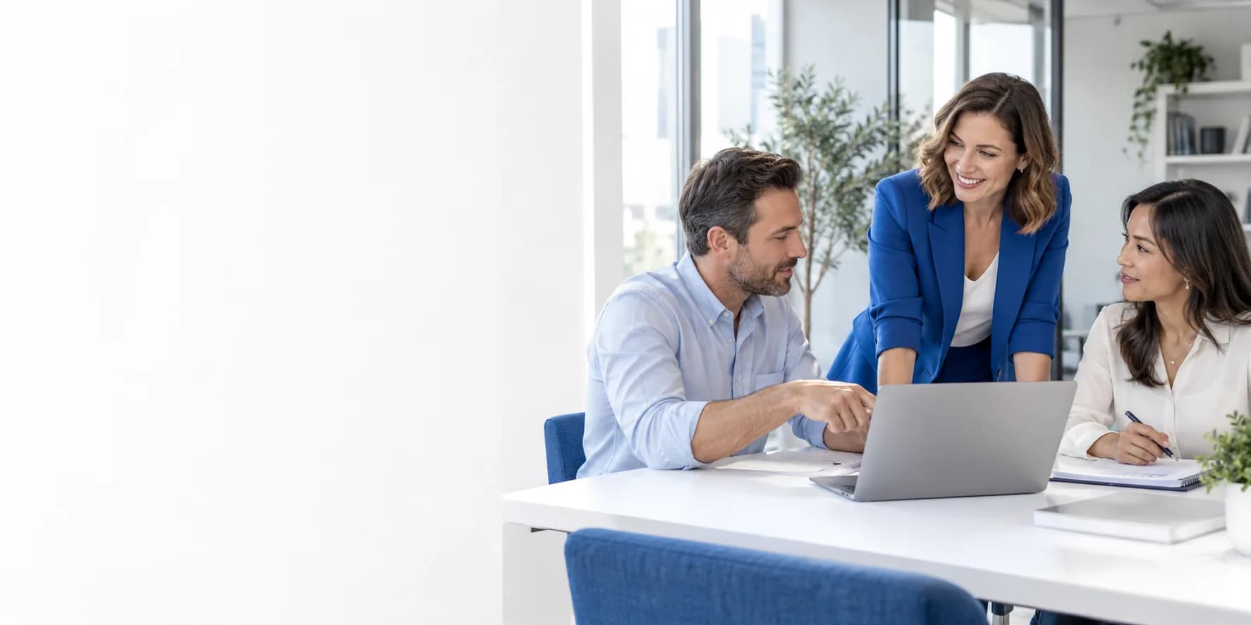 A business owner and two colleagues working through a client proposal together in a bright office